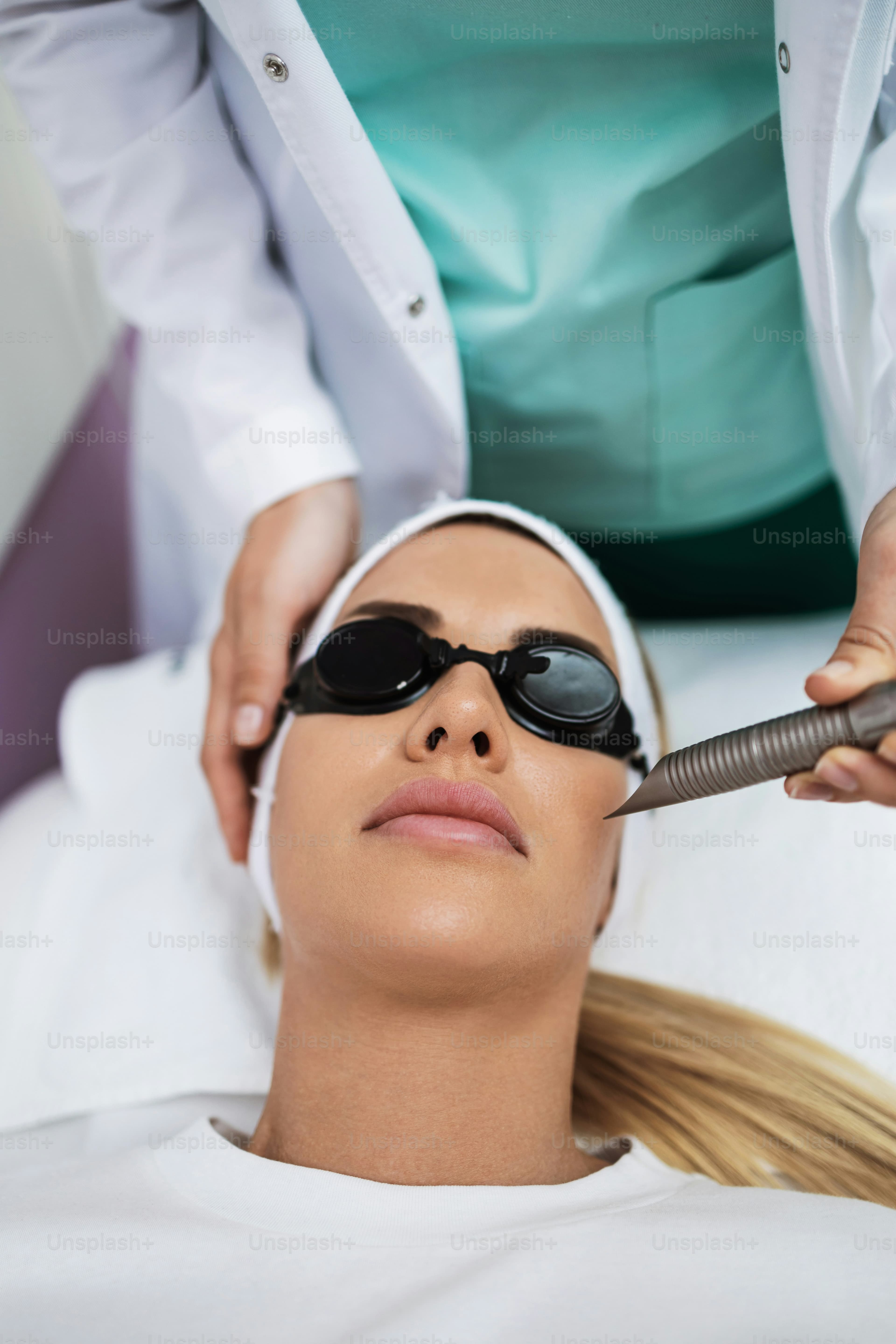 A patient receiving facial laser hair removal with protective eyewear